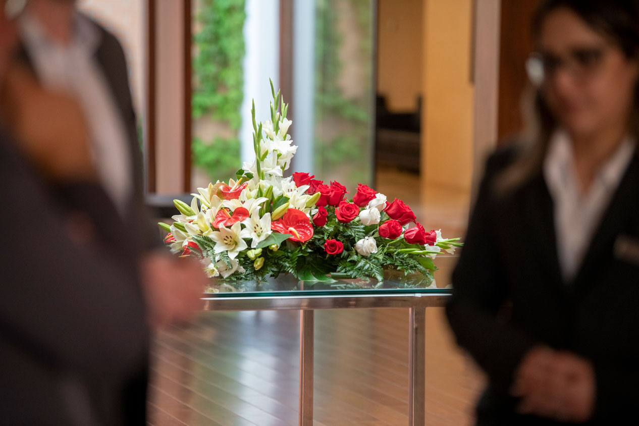 Treballadors de la funeraria amb un centre de flors al fons